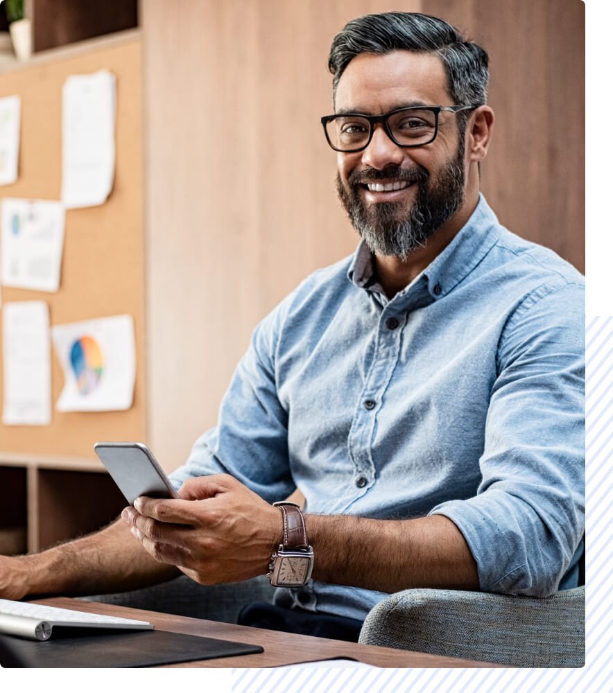 smiling-man-in-office-with-device
